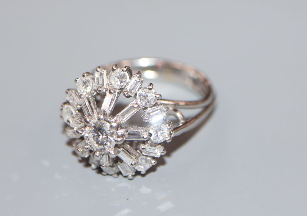 An 18ct and plat, diamond cluster ring, in a raised setting, size J, gross weight 6.7 grams,